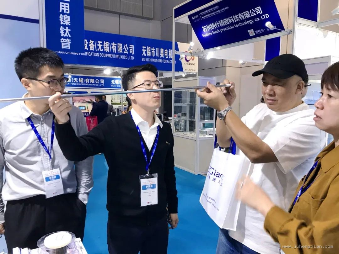 展位前的商务接待与产品洽谈,接待人员为来访客商细致讲解。